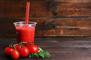 Fresh tomato juice on wooden background