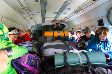 Passengers Inside Cargo Helicopter with Many Backpacks Group of Mountain Climbers Sitting Inside Helicopter with Large Heap of Luggage