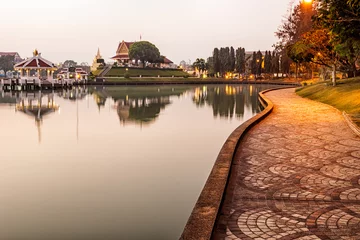 Foto op Plexiglas A walking path beside by lake in city park in Roi Et thailand an early morning © imagesbystefan