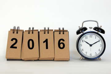 desk standing paper on white background with text new year 2016 and clock