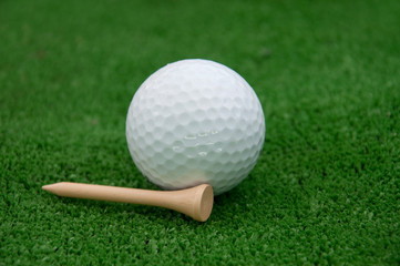 Golf ball and a tee laying beside