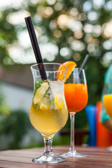 Cold, refreshing and colorful drinks with straws on wooden table.