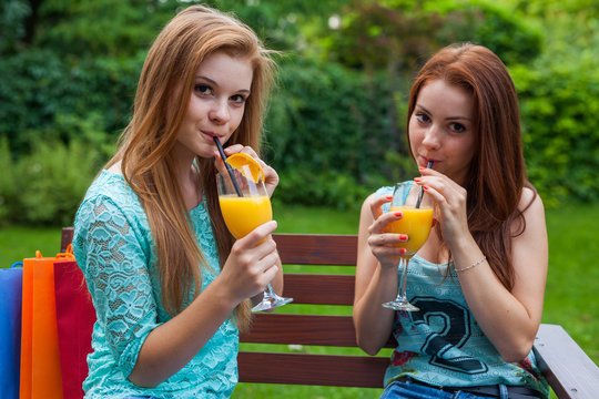 Two friends drink refreshing, cold orange juice.