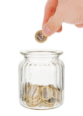 Hand putting one euro coin into money jar isolated on white