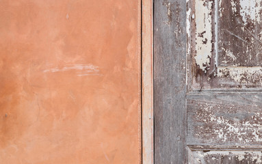 detail of orange cement wall and wooden door texture background