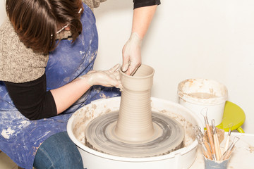 Female Potter creating a earthen jar on a Potter's wheel