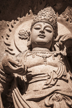 Asian goddess Statue with the sun behind her head