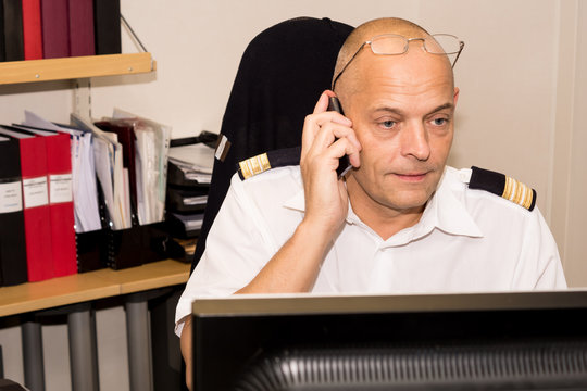 Man pratar i telefon framf&ouml;r dator p&aring; ett kontor