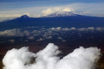 Aerial image of Mount Kilimanjaro, Africa's highest mountain, with snow and white puffy clouds from Kenya