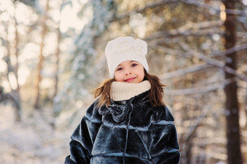 happy child girl on cozy winter forest walk