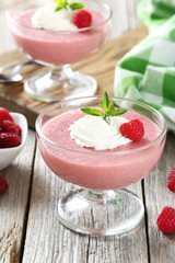 Sweet raspberry mousse in glass on grey wooden table