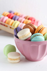 French colorful and tasty macarons in bowl on wooden table