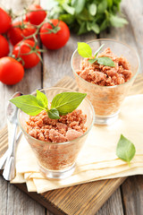 Glass with granita from fresh tomatoes on grey wooden background
