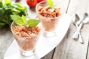 Glass with granita from fresh tomatoes on grey wooden background