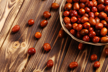 Ripe jujubes on brown wooden table, close up