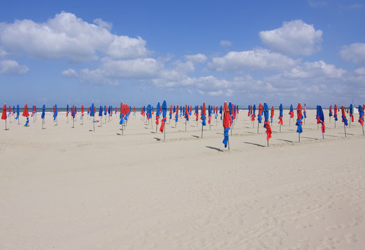 Famous colorful blue and red parasols on Deauville beach, Normandy, France. 