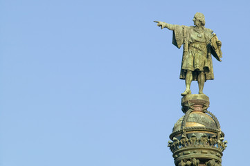 Statue of Christopher Columbus points west to New World, next to waterfront of Port Vell,...