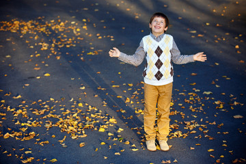 Admiring little boy laughing at beautiful autumn park