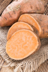Sweet Potato (uncooked) on wooden background