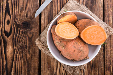 Sweet Potato (uncooked) on wooden background