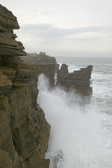 Atlantic ocean sprays water on rocks at Cruz dos Remedios, near Peniche, west coast of Portugal