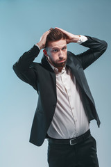 Studio shot of a stylish bearded man in elegant suit, colored tiffany background, isolate thinking,...