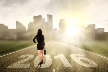Female worker walking on the road with numbers 2016