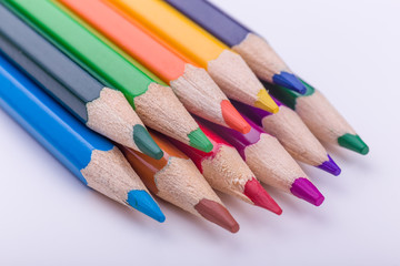 Many different colored pencils on white background