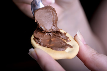 biscuit and chocolate cream in female hand with spoon