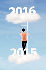Man climbs ladder with numbers 2015 and 2016