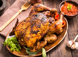 Roasted chicken on wooden plate