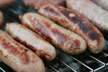 sausages and burgers cooking on barbecue