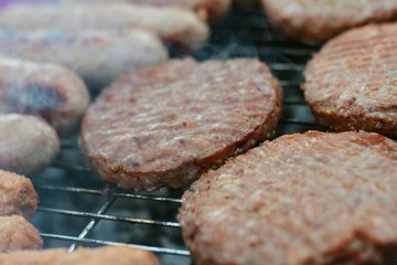 sausages and burgers cooking on barbecue