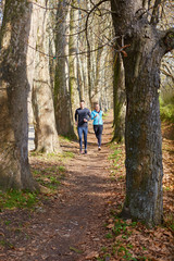 Fototapeta na wymiar Young running couple jogging in autumn nature
