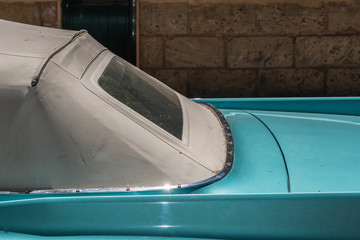 Closeup of legendary classic car in retro turquoise color. Vintage automobile American 50s style, extravagant convertible