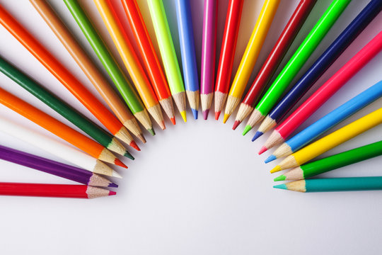 coloring pencils in a half-circle centered top view shot on a white background