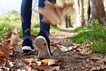 close up of feet of a runner running in autumn leaves training f
