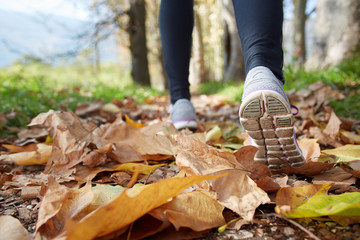 close up of feet of a runner running in autumn leaves training f