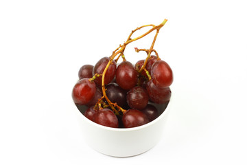 Red grapes in white bowl isolated