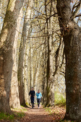 Young couple running together in park - fall nature