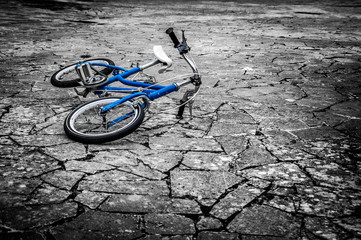 Artistic dark vintage edit of a left children's bicycle on a cracked floor