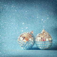 image of christmas festive decorations on blue glitter background. retro filtered with glitter overlay. selective focus
