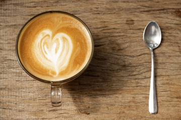 cup of latte art coffee on wooden background