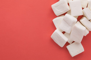 Pile of original marshmallows in red pastel background.