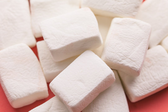 Pile of original marshmallows in red pastel background.