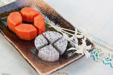 papayas and dragon fruit on table cloth