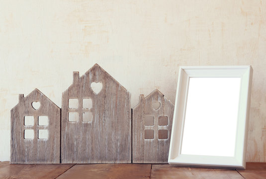 image of vintage wooden house decor, blank frame on wooden table and stars garland. selective focus