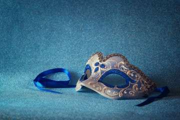 blue female carnival mask and glitter background. with glitter overlay
