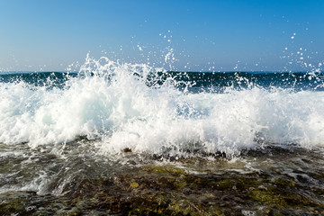 Waves breaking on a stony beach, forming sprays