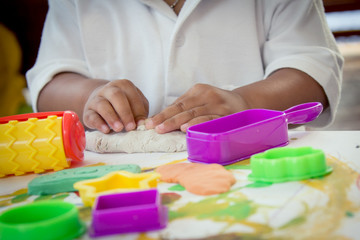 Obraz na płótnie Canvas Child hand playing with clay, play doh